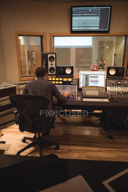 Ingeniero de audio usando mezclador de sonido en estudio de grabación - foto de stock