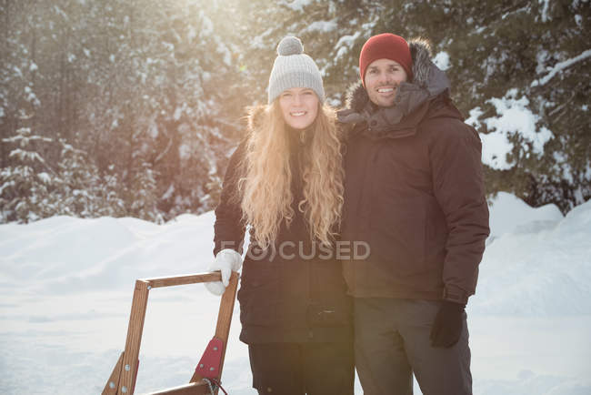 Мушеры, стоящие рядом с санями на снежном ландшафте — стоковое фото