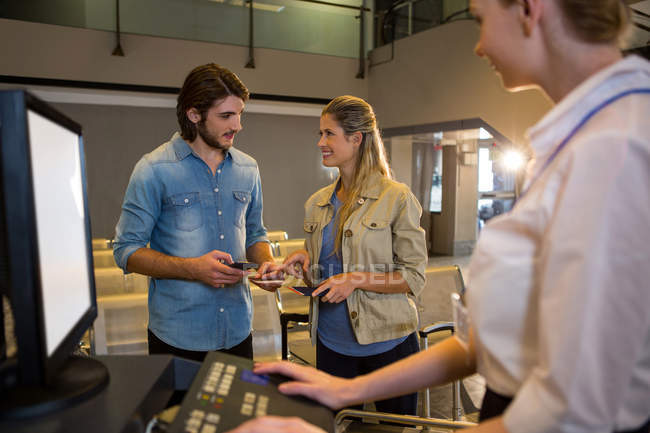 Coppia che interagisce tra loro al banco check-in del terminal aeroportuale — Foto stock