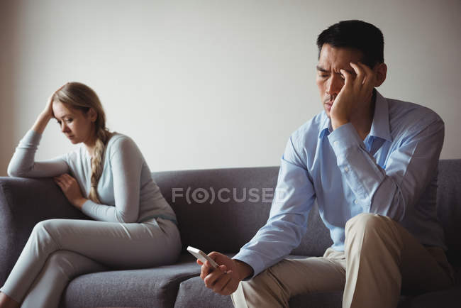 Verärgertes Paar sitzt auf Sofa und ignoriert einander — Stockfoto