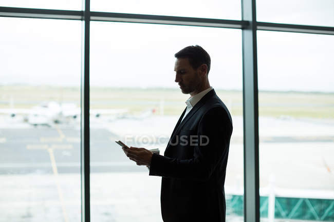 Бизнесмен, использующий цифровой планшет в зоне ожидания в аэропорту — стоковое фото