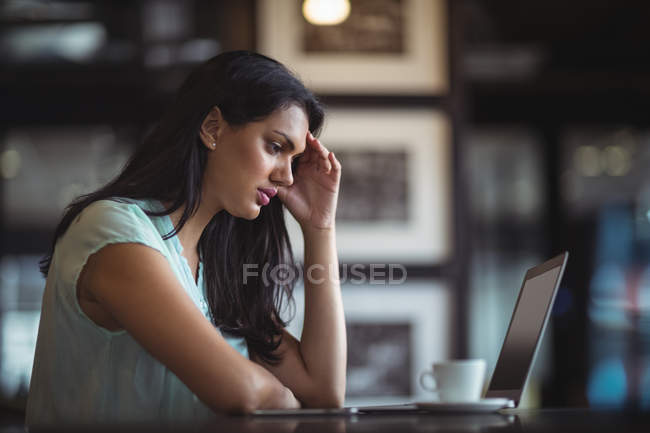 Empresaria trastornada sentada en su escritorio en la oficina - foto de stock