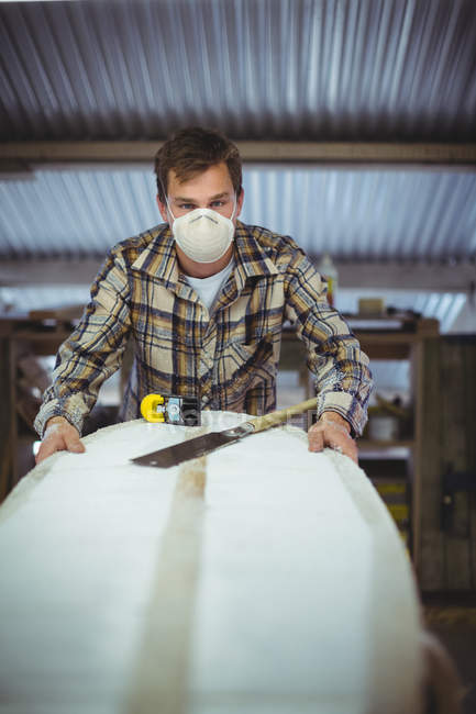 Frontansicht eines Mannes, der in der Werkstatt Surfbretter bastelt — Stockfoto