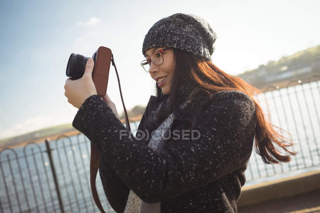 Mulher sorridente tirando fotos na câmera digital — Fotografia de Stock