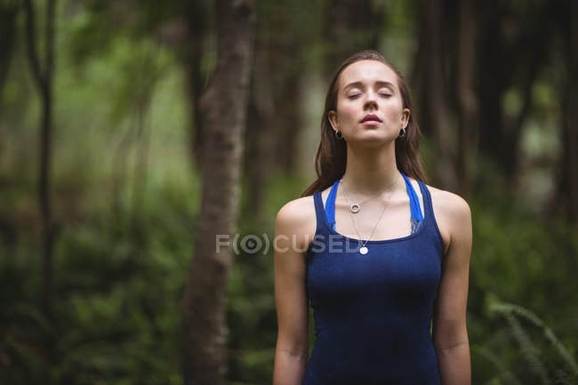 Woman performing yoga in forest on a sunny day — Stock Photo