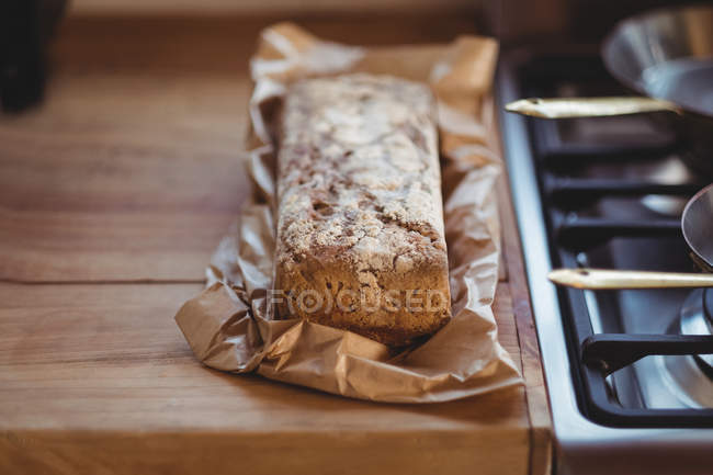 Primer plano del pan horneado en la mesa de madera - foto de stock