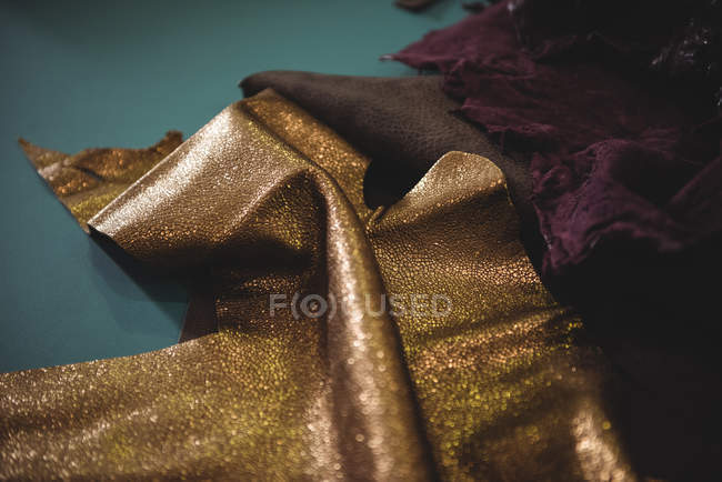 Piece of leather on green table in workshop — Stock Photo