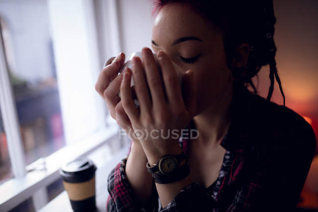Beautiful woman having a cup of coffee in cafe — Stock Photo