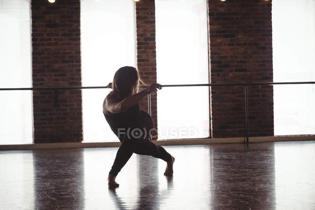 Femme pratiquant la danse contemporaine en studio de danse — Photo de stock