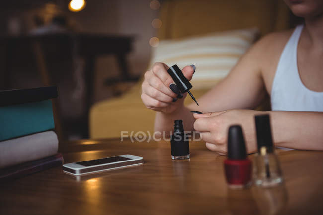 Жінка застосовує лак для нігтів в домашніх умовах — стокове фото