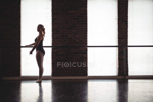 Ballerina practicing ballet dance at barre in the ballet studio — Stock Photo