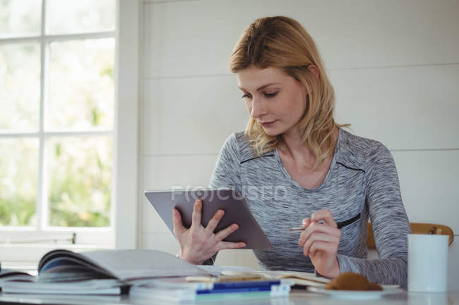 Женщина пользуется цифровым планшетом в гостиной дома — стоковое фото