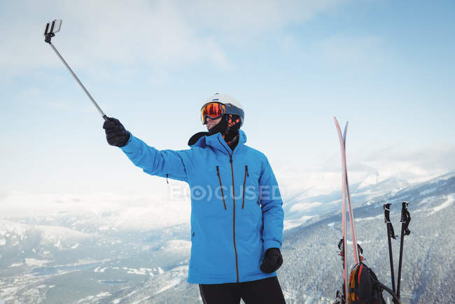 Лыжник делает селфи на заснеженной горе — стоковое фото