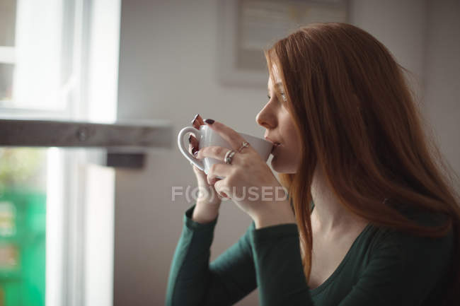 Красивая женщина пьет кофе в ресторане — стоковое фото
