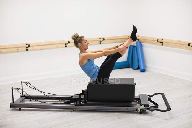 Frau trainiert an Reformer-Geräten im Fitnessstudio — Stockfoto
