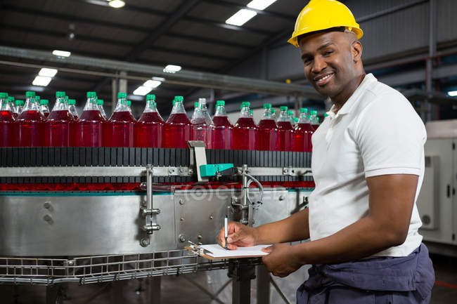 Portrait of young male worker noting in factory — Stock Photo