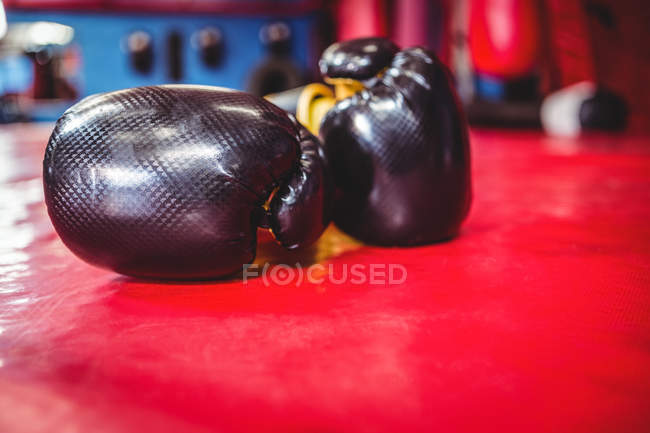 Par de luvas de boxe na superfície vermelha no estúdio de fitness — Fotografia de Stock