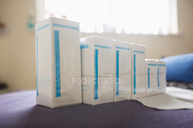 Gros plan des boîtes à aiguilles sèches sur le lit de la clinique — Photo de stock