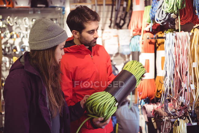 Coppia selezionando la corda da arrampicata insieme in un negozio — Foto stock