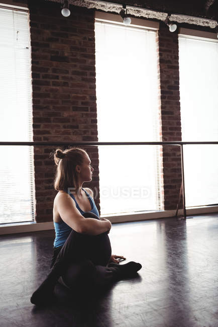 Jovem dançarina realizando exercícios de alongamento no estúdio de dança — Fotografia de Stock