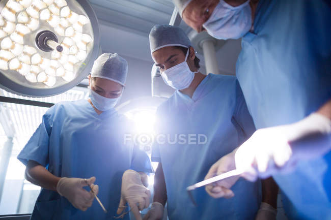 Grupo de cirurgiões que realizam operação em sala de operação no hospital — Fotografia de Stock