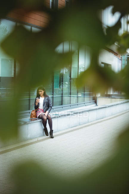 Frau benutzt Handy außerhalb des Bürogebäudes — Stockfoto