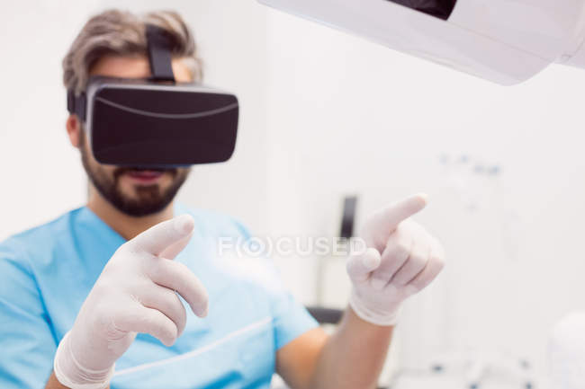 Стоматолог, использующий гарнитуру виртуальной реальности в стоматологической клинике — стоковое фото