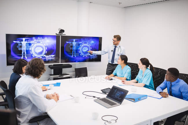 Arzt stellt Team von Interimsärzten im Konferenzraum vor — Stockfoto