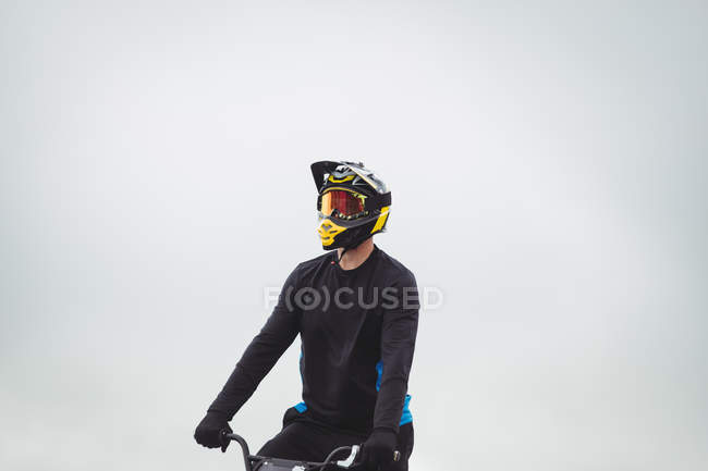 Велогонщик сидит на велосипеде BMX в скейтпарке — стоковое фото