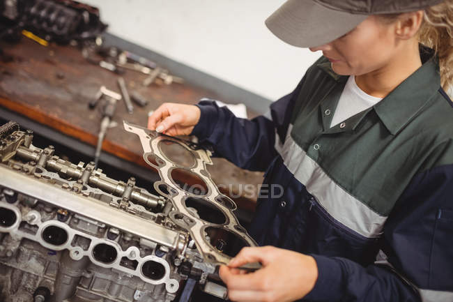 Жінка-механік перевіряє деталі автомобіля в ремонті гаража — стокове фото