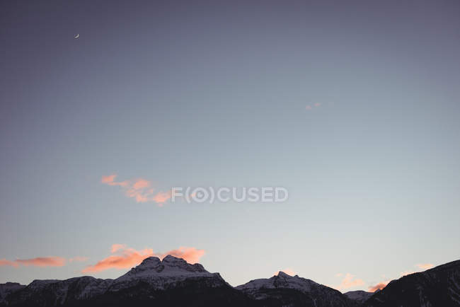 Vista panorâmica das montanhas cobertas de neve durante o inverno ao pôr do sol — Fotografia de Stock
