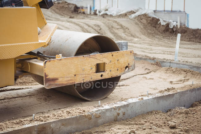 Gros plan sur la boue de nivellement des rouleaux routiers sur le chantier — Photo de stock