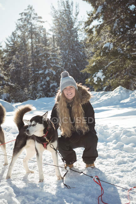 Woman petting Siberian dog during winter — Stock Photo