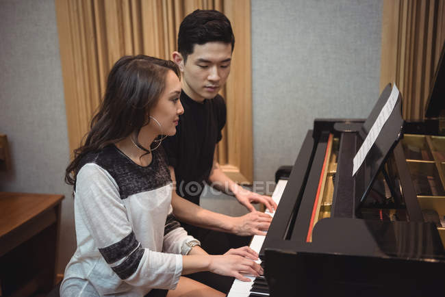 Пара, играющая на пианино в студии звукозаписи — стоковое фото