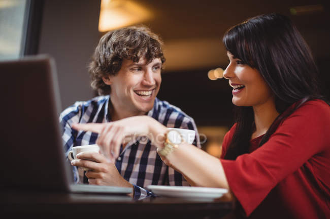 Paar benutzt Laptop beim Kaffeetrinken im Restaurant — Stockfoto