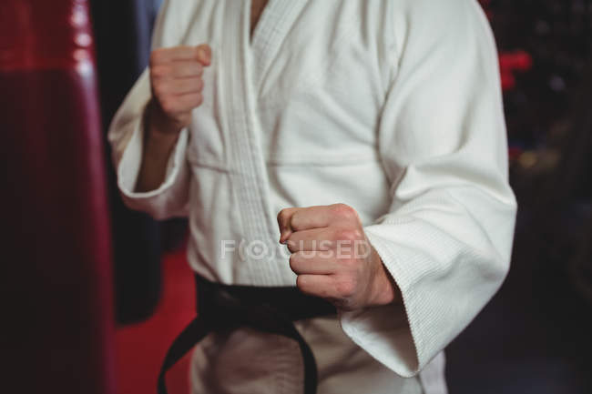 Sezione intermedia del giocatore di karate che esegue la posizione di karate in palestra — Foto stock