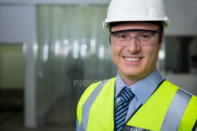 Technician in hard hat and protective eyewear at factory — Stock Photo