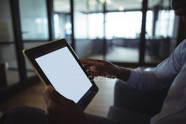 Primer plano del hombre de negocios utilizando tableta digital en la oficina - foto de stock
