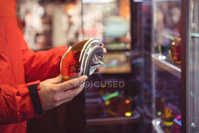 Nahaufnahme eines Mannes bei der Auswahl einer Skibrille in einem Geschäft — Stockfoto