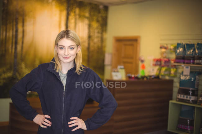 Portrait of confident woman standing with arms akimbo in office — Stock Photo