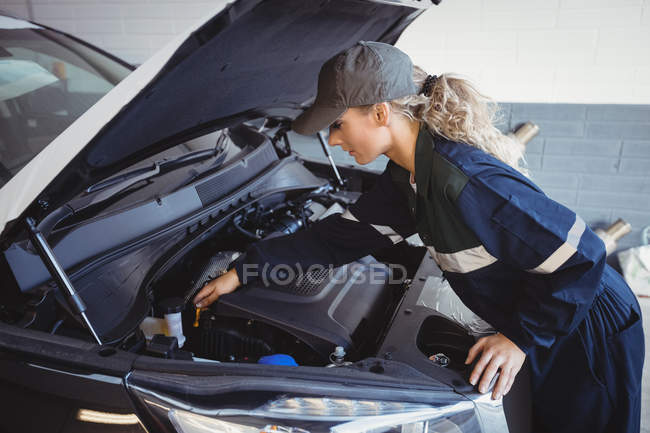 Feminino mecânico de manutenção de carro na garagem de reparação — Fotografia de Stock