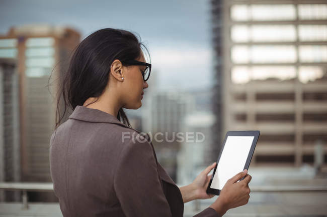 Femme d'affaires utilisant une tablette numérique sur la terrasse du bureau — Photo de stock