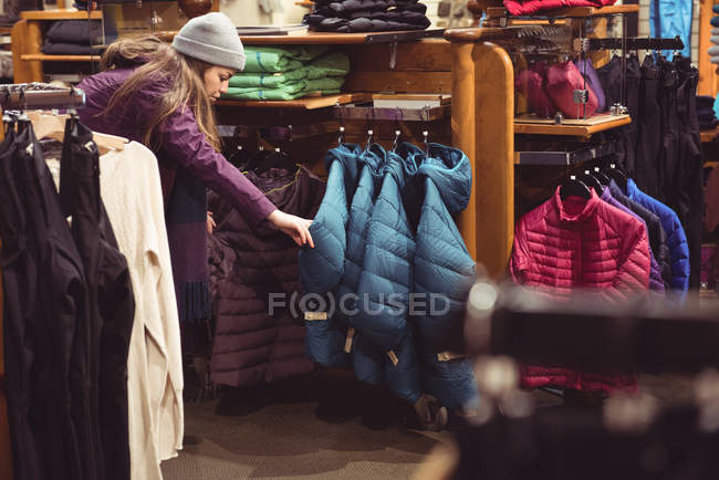 Жінка вибирає одяг в магазині одягу — стокове фото