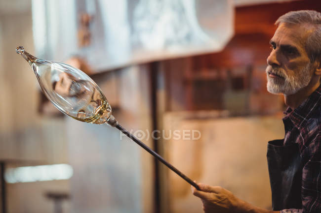 Soffiatore di vetro che modella un vetro fuso alla fabbrica di soffiaggio del vetro — Foto stock