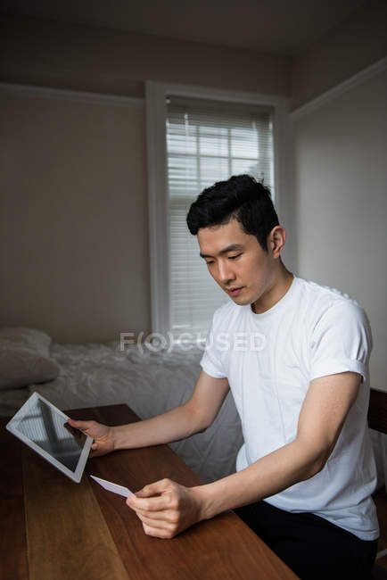 Мужчина делает онлайн покупки на цифровых планшетах дома — стоковое фото