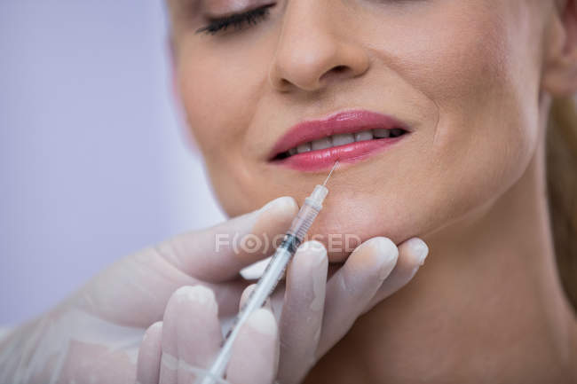 Nahaufnahme einer erwachsenen Frau mit Botox-Spritze in Klinik — Stockfoto
