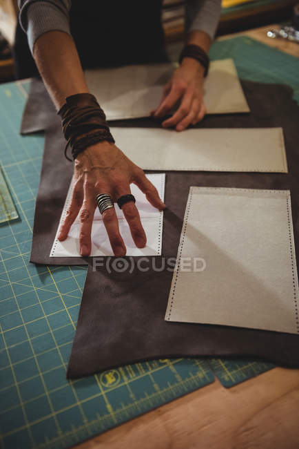 Metà sezione di artigiana organizzare pezzo di pelle sul tavolo da lavoro in officina — Foto stock