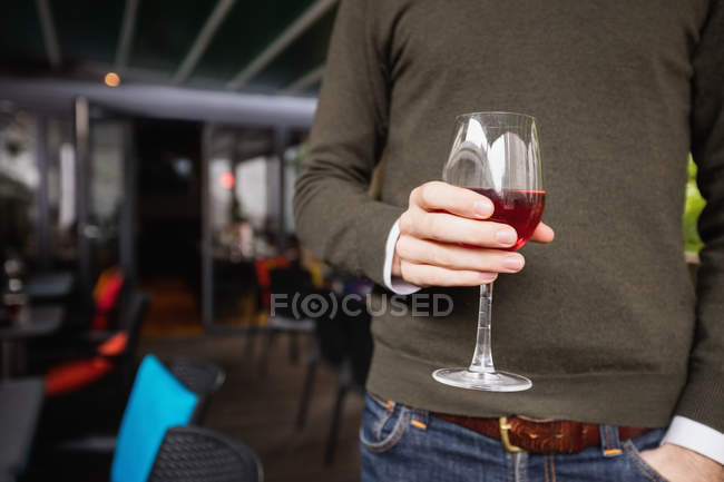 Середина чоловіка тримає келих вина в барі — стокове фото
