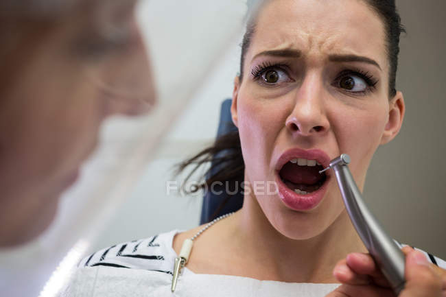 Молодая женщина испугалась во время осмотра зубов в клинике — стоковое фото
