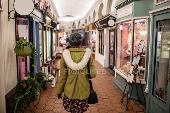 Vue arrière de la femme marchant dans l'intérieur du marché vintage — Photo de stock